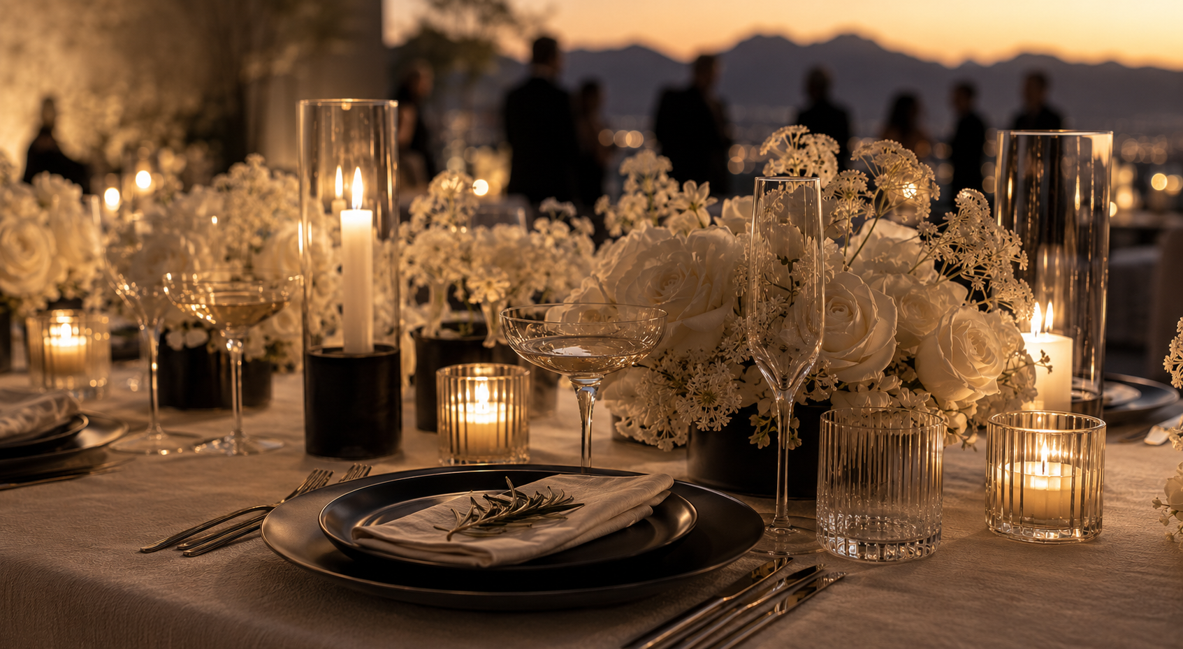 Intimate candlelit place setting with white roses and crystal glassware at dusk.